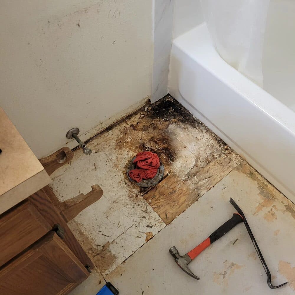 Bathroom subfloor preparation showing exposed joists during renovation